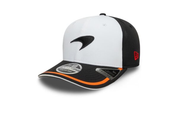 Bring bold energy and retro flair to your F1 style with the McLaren New Era Retro 9SEVENTY Stretch Snap Cap. Designed in a striking white and black colorway with signature papaya accents, this cap blends classic motorsport design with a comfortable modern fit. Featuring an embroidered McLaren speedmark logo and curved visor, it’s perfect for true McLaren fans who want a standout piece with a clean, structured look. Official McLaren F1 Team cap by New Era 9SEVENTY Stretch Snap silhouette Color: White front panels, Black rear panels, Papaya visor piping Embroidered McLaren speedmark logo on front Curved pre-shaped visor with papaya edge and underside Structured low-profile crown Adjustable stretch-snap back closure for a flexible fit Embroidered New Era flag on the left side Ventilation eyelets for breathability Moisture-wicking sweatband inside Made from a soft and flexible cotton blend One size fits most adults