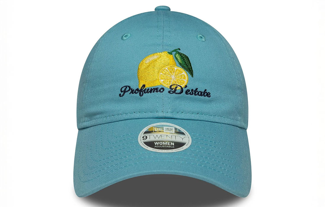 60691297_1 front Women New Era Phrase Pastel Blue 9TWENTY Cap Lemon graphic with Profumo D'estate (Smells of Summer) wordmark in Italian on front New Era Flag embroidered on left Unstructured crown Strapback Curved visor 100% COTTON Product ID: 60691297