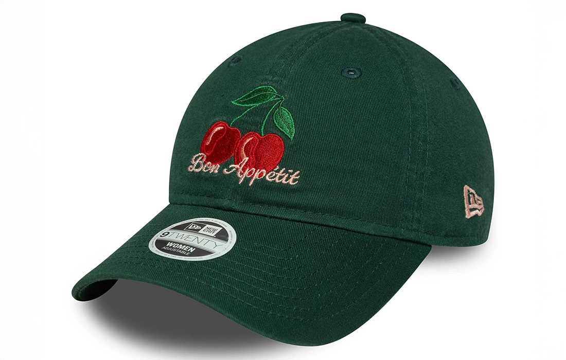 60691298 side Women New Era Phrase Dark Green 9TWENTY Cap Cherry graphic with Bon Appetit (Enjoy Your Meal) wordmark in French on front New Era Flag embroidered on left Unstructured crown Strapback Curved visor 100% COTTON Product ID: 60691298